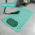 Green bath mat with textured surface on a tiled floor, featuring the text &